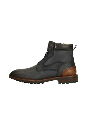 Heren enkelboots in donkerblauw textiel met bruine leren accenten, ronde neus, vetersluiting en een gestructureerd oppervlak voor grip.