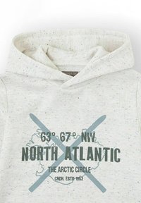 Sudadera con capucha gris claro y textura, con un patrón moteado. Presenta un texto gráfico en verde oscuro y azul, que incluye coordenadas y 'ATLÁNTICO NORTE'.