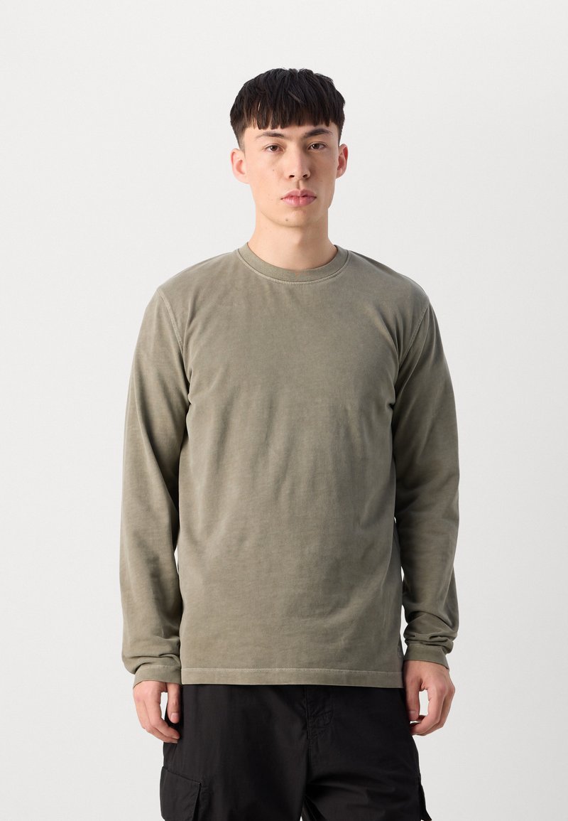 Chemise à manches longues de couleur vert olive, confectionnée en tissu doux, avec un col rond et une coupe décontractée. Pas de motifs distincts ni de détails matériels.