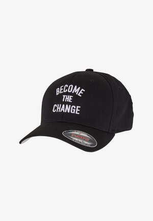 Čierna čiapka z látky s bielym vyšívaným textom "BECOME THE CHANGE" na prednej strane, zakriveným billom a nálepkou Flexfit na okraji.