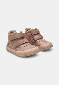 Sneakers in pelle marrone, di dimensioni per bambini, con doppie cinghie in velcro e suole in gomma leggera su sfondo bianco semplice.