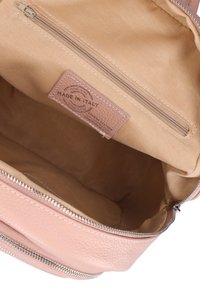 Borsa in vera pelle di un delicato rosa, con chiusura a zip, texture liscia e interno in tessuto beige con una piccola tasca con zip.