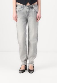 Jeans in denim grigio chiaro con vestibilità dritta, dotati di un classico design a cinque tasche e dettagli di cucitura visibili.