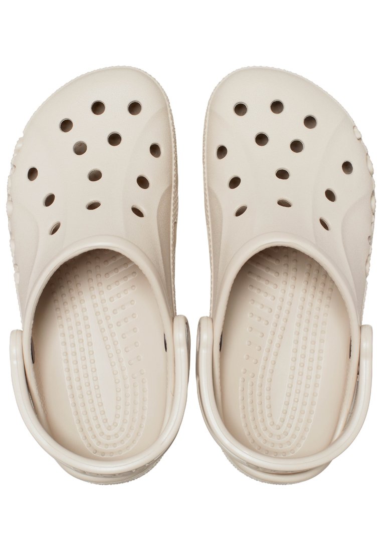 Lichtbeige klompen met perforaties voor ventilatie, gemaakt van duurzaam plastic. Voorzien van een gestructureerde voetbed en een gebogen rugband voor ondersteuning.