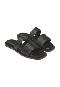 Sandali in pelle nera con soletta piatta, caratterizzati da due ampie cinghie lisce e una punta quadrata. Aspetto minimalista ed elegante.