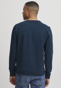Navyblauwe sweatshirt met ronde hals en lange mouwen, gemaakt van zacht materiaal, met ribben bij de manchetten en onderkant voor comfort en pasvorm.