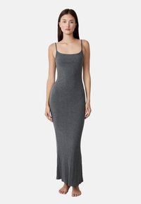 Vestido largo y ajustado de canalé gris con tirantes finos y dobladillo acampanado, hecho de un material suave y elástico.