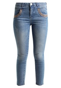 Slitna jeans i ljusblå denim med slitna detaljer, hög midja och dekorativ sömnad på fickorna. Slät textur.