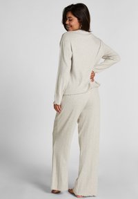 Lichtgrijs, textuur loungewear set met een langemouwen top en brede pijpen met een scalloped zoomdetail. Zacht, relaxte pasvorm.