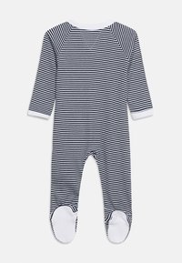 Μπλε ναυτικό και λευκό ριγέ μακρυμάνικο βρεφικό φορμάκι με καλυμμένα πόδια, με λευκές μανσέτες και λαιμόκοψη, απλωμένο επίπεδα σε λευκό φόντο.