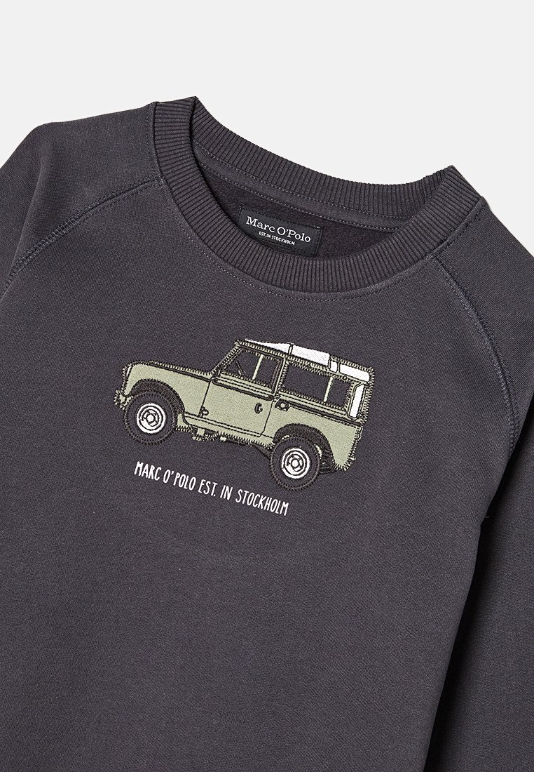 Szara bluza z ribbowanym dekoltem z haftowanym zielonym pojazdem w stylu vintage i napisem "Marc O'Polo EST. W Sztokholmie" poniżej.