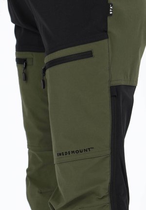 Groene en zwarte outdoorbroek met een contrasterend ontwerp, voorzien van ritszakken en het "SWEDEMOUNT™"-logo aan de zijkant.