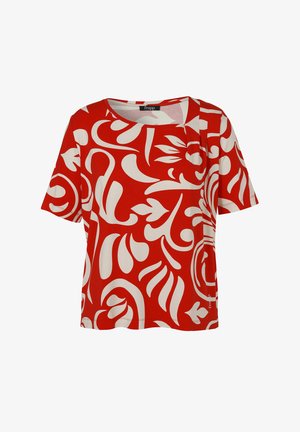 Blouse rouge à manches courtes avec grand motif abstrait blanc floral et tourbillonnant, col rond et coupe décontractée.