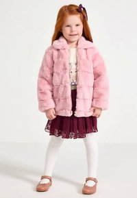 Pink faux-fur jacket with a button-up front, worn over a white top. Burgundy lace skirt, white tights, and brown shoes complete the outfit.