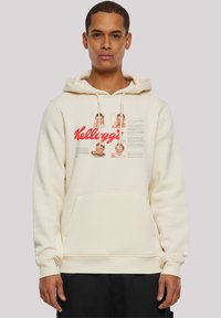 Cremefarbener Hoodie aus weichem Stoff mit einer Fronttasche, Kordelzug und bunten Grafiken von Kindern sowie einem großen roten "Kellogg's"-Logo.