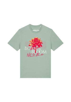 Hellgrünes T-Shirt mit einer roten und orangen Blume als Grafik und dem Text "Born to bloom, not to fit in" auf der Vorderseite.
