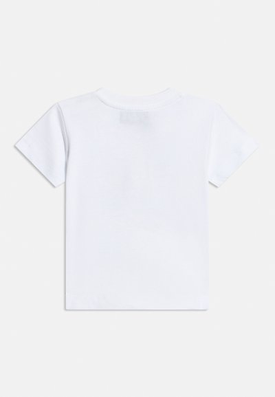 Απλό λευκό κοντομάνικο μπλουζάκι με στρογγυλή λαιμόκοψη, εμφανιζόμενο από πίσω σε ανοιχτό γκρι φόντο.