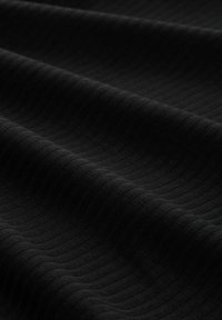 Zwart ribfluweel met een zachte textuur, met subtiele groeven die horizontaal over het oppervlak lopen, wat diepte en dimensie creëert.