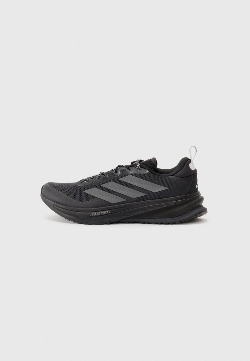 Baskets noires de sport avec une tige en maille, design à trois bandes grises, col rembourré, semelle texturée et accents réfléchissants.