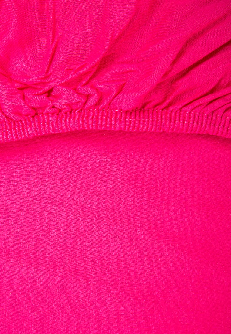 Un tissu rose vif avec une texture lisse, présentant un élastique froncé en haut et une section plate et uniforme en dessous.