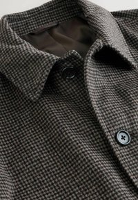 Brown and black small checkered wool coat with black buttons and a folded collar, showing a smooth dark brown inner lining.