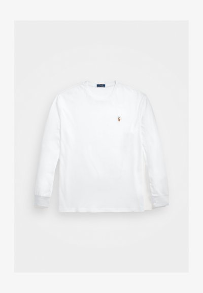 Pitkähihaista valkoista puuvillapaitaa, jossa on pyöreä kaula-aukko ja ribbausmanchetit, ja rinnassa pieni brodeerattu logo.