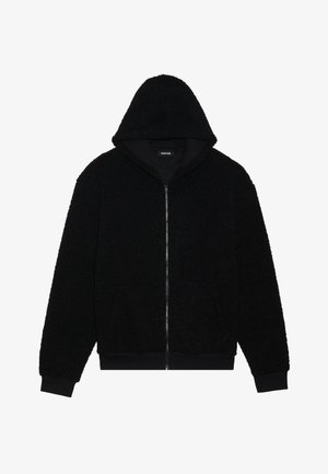 Must mustaga kapuutsiga, mis on valmistatud tekstuurist ja karvase kangaga. Omab kapuutsi, soonikkoes randmeid ja äärepidi. Lihtne kujundus, ilma nähtavate mustrite või aksessuaarideta.