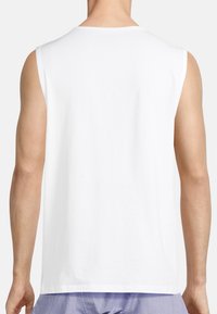 White sleeveless cotton tank top with a rounded neckline, smooth texture, and minimal stitching, viewed from the back.
