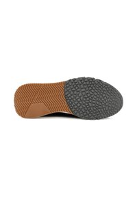 Rubberen zool met een bicolor ontwerp; bruine visgraatstructuur aan de voorkant en gestructureerd grijs rubber aan de achterkant voor grip en houvast.