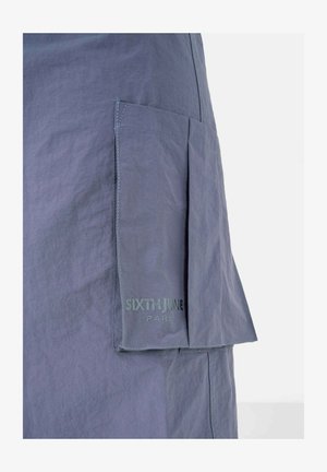 Falda de tela gris con un bolsillo lateral, que presenta detalles cosidos y un logo impreso "SIXTH JUNE PARIS" en letras discretas.