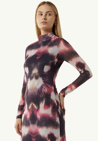 Langärmliges, figurbetontes Kleid mit hohem Kragen, das ein mehrfarbiges abstraktes Muster in Schattierungen von Pink, Violett und Schwarz aufweist. Glatte Textur.