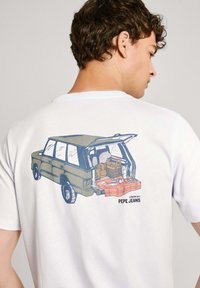 Camiseta blanca de algodón con un gráfico de un vehículo verde abierto con suministros en el maletero, etiquetado "Pepe Jeans" debajo del diseño.
