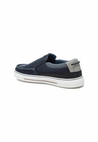 Zapatillas navy de slip-on con parte superior de lona, detalles en gris, suela de goma blanca y franja roja. Textura suave y diseño redondeado.
