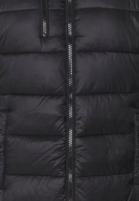 Černá péřová bunda s prošívanými částmi, plným zipem a hladkým nylonovým materiálem. Vyznačuje se matným povrchovým vzhledem bez viditelných log.