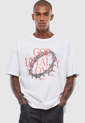 White cotton t-shirt featuring a graphic print with "GOD LOYALTY LOVE" in red and a black thorn crown design. Loose fit, short sleeves.