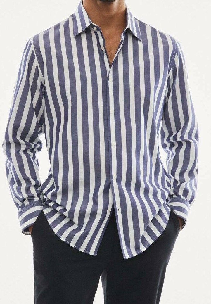 Camicia a righe blu e bianche in tessuto leggero, con chiusura frontale a bottoni, maniche lunghe e orlo curvo.