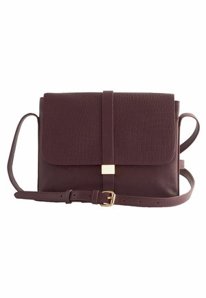 Sac bandoulière en cuir marron foncé avec rabat à texture crocodile, boucle dorée et sangle ajustable sur fond blanc.