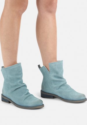 Stivali alla caviglia blu perforati con design arricciato, tacco basso impilato e bordo in blu scuro a contrasto attorno alla suola. Materiale texturizzato.