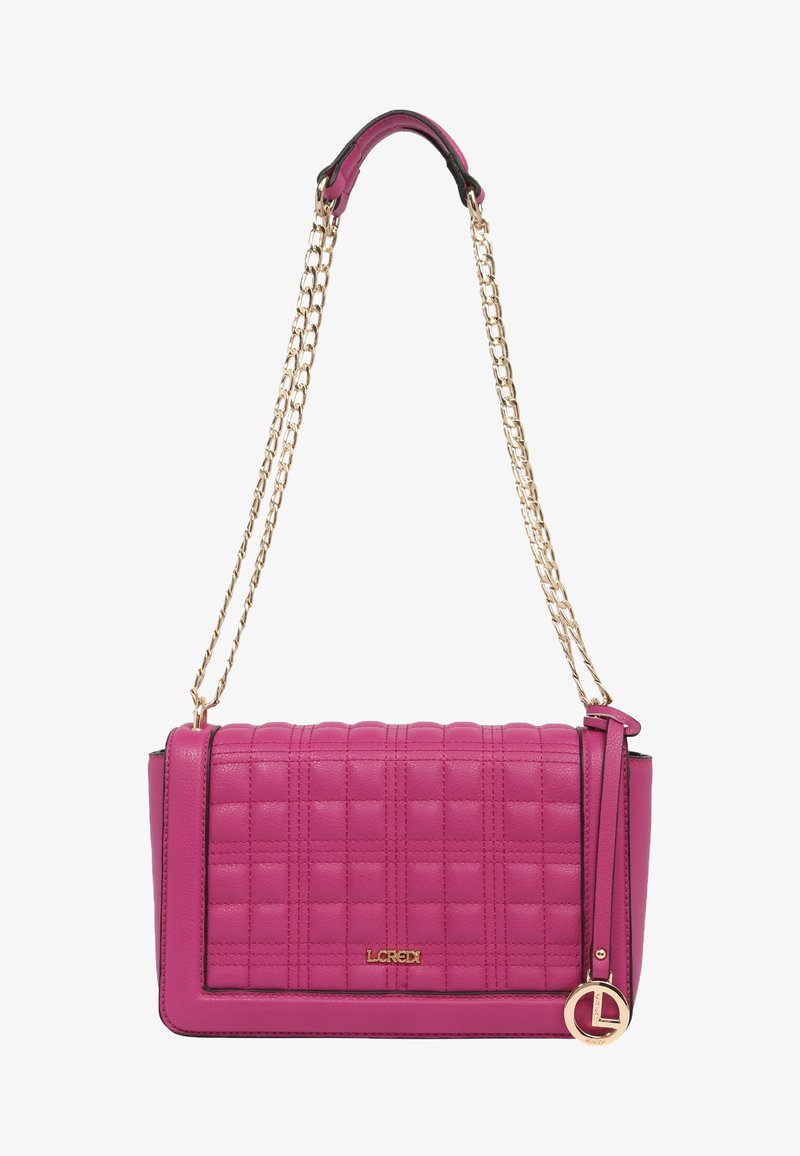 Sac à main en cuir matelassé rose avec une bandoulière chaîne dorée et un pendentif rond avec logo doré suspendu sur le côté.