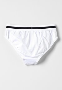 Witte katoenen slip met een zwarte elastische tailleband. De stof is glad en iets rekbaar, met een klassiek slipsontwerp.