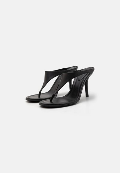 Sandale negre cu toc, prezentând un design elegant cu bretele din piele și un suport pentru degete. Textura netedă și silueta minimalistă pun în evidență eleganța încălțămintei.