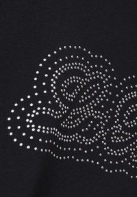 Material negru cu un model spiralat de cuie metalice, creând un design texturat. Cuile variază ca mărime și sunt aranjate strâns.