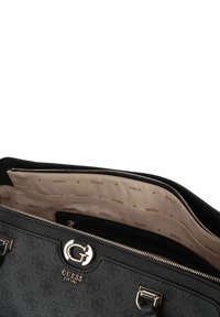 Zwarte handtas met textuur en zilverkleurige hardware, voorzien van een logo, ritssluiting, meerdere binnencompartimenten en een beige met patroon gevoerde binnenkant.