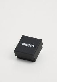 Svarte pappeske med firkantet form, med et metallisk sølvtrykt logo som leser "WASTED PARIS" på toppen og en teksturert finish.