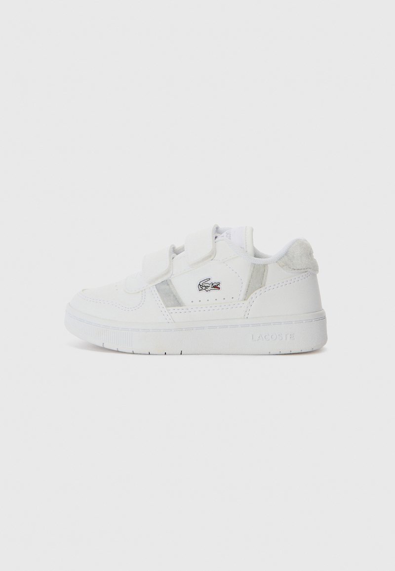 Baskets blanches avec une tige en cuir lisse, deux bandes Velcro, des accents gris subtils, et une semelle en caoutchouc texturée avec un détail de logo.
