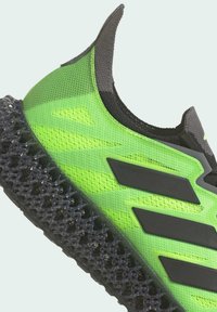 Scarpa sportiva verde con tomaia in mesh testurizzato, con accenti neri e una suola nera a punta unica per una maggiore aderenza.