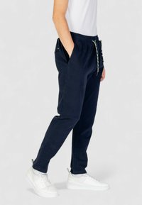 Pantaloni jogger blu navy con vita elastica, tasche frontali e cordoncino decorativo. Realizzati in tessuto morbido, presentano una vestibilità comoda.