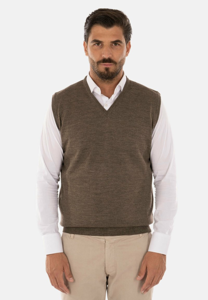 Gilet in lana marrone con scollatura a V, indossato sopra una camicia bianca. Texture liscia, senza motivi, presenta una vestibilità aderente e orlo a costine.