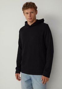 Schwarzer Hoodie mit langen Ärmeln und Kordelzug, aus weichem Stoff gefertigt. Verfügt über einen lässigen Schnitt und eine Kängurutasche. Legeres Design, das sich gut zum Layering eignet.