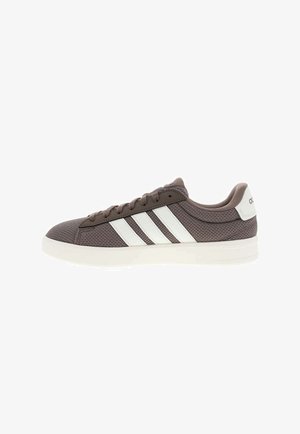 Sneaker Adidas marron, modèle basse, avec des bandes blanches, un passant de talon blanc, une tige en mesh et une semelle blanche, vue de profil.